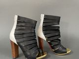 black and white high heeled boots with gold accents on the toes