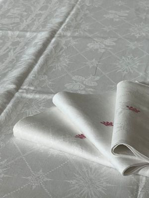 deux serviettes pliées posées sur un lit recouvert d'une couette blanche