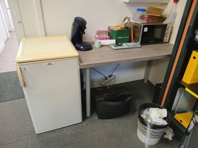 une photo d'une cuisine avec un réfrigérateur et une petite table
