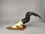 an image of a sculpture of a goat ' s skull on a wooden base