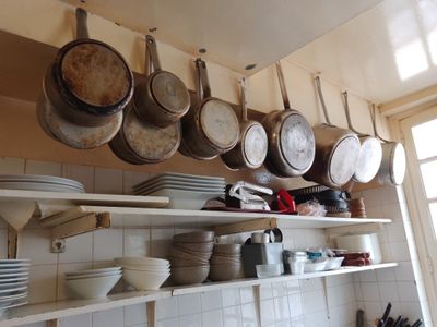 de nombreuses casseroles et poêles suspendues au plafond de la cuisine