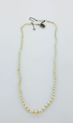 a necklace and earring set with pearls on a white background