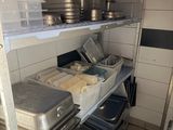 many pans and pans on the shelves in the kitchen
