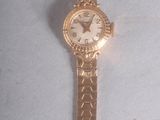 an image of a gold watch with a white face on a white surface
