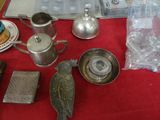 a red table with silver objects on it and a bird on the table