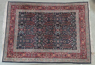 un tapis oriental posé au sol, avec une bordure noire et rouge
