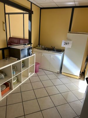 une petite cuisine équipée d'un micro-ondes et d'un réfrigérateur