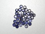 un gros plan sur un bouquet de saphirs bleus posés sur une surface blanche