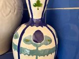 un vase posé sur une étagère à côté d'un autre vase