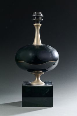 une image représentant un vase noir et doré posé sur un socle noir