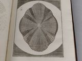an open book with a drawing of a circular object on it
