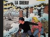 On y voit la couverture de la bande dessinée « Les Long, le shérif ».