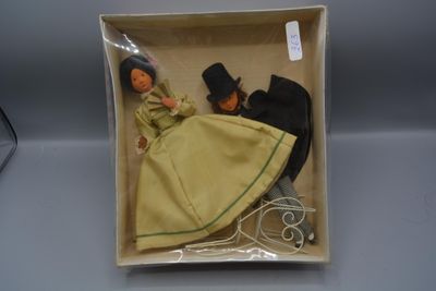 une poupée dans une boîte, avec un chapeau et une robe