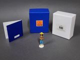 une petite figurine représentant un homme debout à côté d'une cabine téléphonique bleue