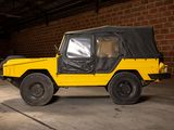 a yellow jeep with a black cover parked in a garage