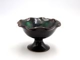 a black bowl on a black pedestal on a white background