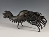 une statue en bronze représentant un homard avec de grandes pinces sur le dos