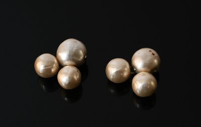 deux paires de perles reposent sur une surface noire