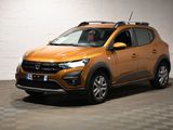 la voiture orange est garée dans le garage sur un sol en damier