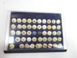 a lot of buttons in a display case on the table