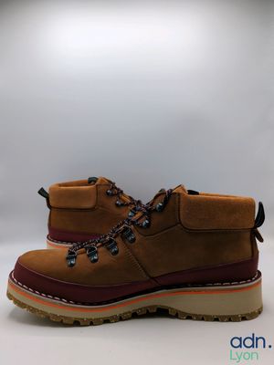 men ' s brown boots with brown soles on a white background