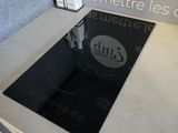 a glass stove top with a black burner on it