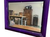 un miroir violet accroché au mur d'une pièce