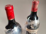 two bottles of wine that have been wrapped in plastic