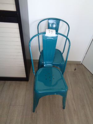 une chaise bleue placée à côté d'une autre chaise bleue dans une pièce