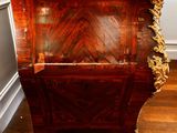 a wooden cabinet with a marble top on a hard wood floor