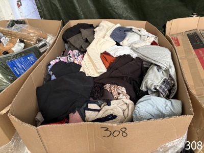a cardboard box full of clothes sitting on the floor