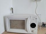 a white microwave sitting on a wooden table in a room