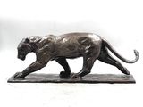 bronze statue of a lion on a marble base with a white background