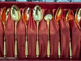 a red box filled with gold spoons and spoons