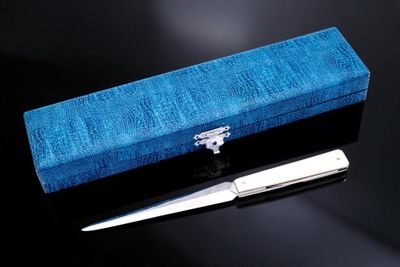 une boîte bleue avec une paire de ciseaux à côté