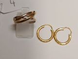 two pairs of gold hoop earrings on a white surface