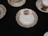 five cups and saucers on a table with a black table cloth