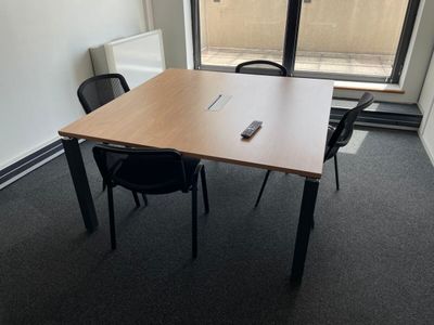 une table sur laquelle se trouve une télécommande, dans une pièce
