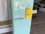 un réfrigérateur bleu sur lequel est accrochée une étiquette jaune, dans un salon