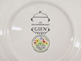 a white plate with a picture of a pot and flowers on it