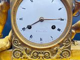 a gold clock with a statue on top of it