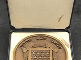 une médaille d'or dans un écrin noir posé sur une table