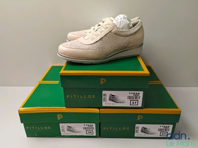 Des cartons de chaussures de tennis sont empilés les uns sur les autres sur une table
