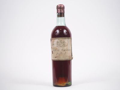 une vieille bouteille de vin posée sur une surface blanche