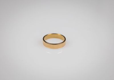 a gold ring sitting on top of a white surface