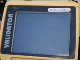 someone is holding a yellow and black handheld computer with a blue screen