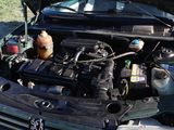a car engine with the hood open and a gas can in the trunk