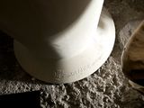 a white toilet and a pair of shoes on the floor