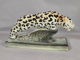 figurine of a leopard on a rock on a white background
