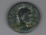 une vieille pièce de monnaie sur laquelle est représenté un visage, posée sur une table